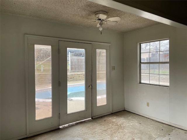 doorway to outside with ceiling fan and a textured ceiling