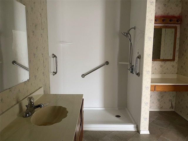 full bathroom featuring tile patterned floors, a shower stall, vanity, and wallpapered walls