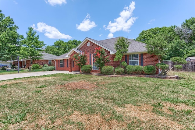 ranch-style house featuring brick siding, driveway, a front lawn, and fence