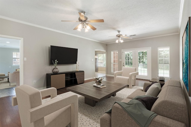 living area with ornamental molding, wood finished floors, visible vents, and a textured ceiling