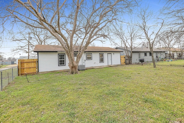 back of property featuring a fenced backyard, central AC unit, and a yard