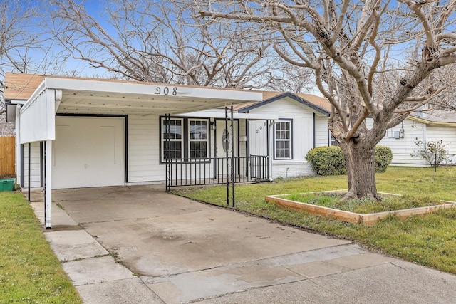 view of front of property featuring brick siding, fence, concrete driveway, and a front yard