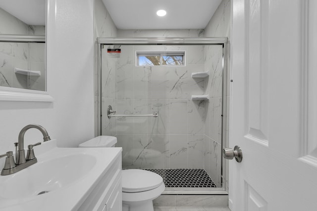 full bath featuring toilet, a marble finish shower, and vanity