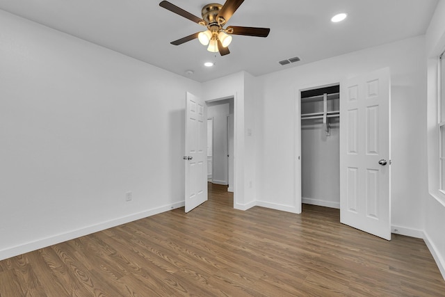 unfurnished bedroom with recessed lighting, wood finished floors, a ceiling fan, visible vents, and baseboards