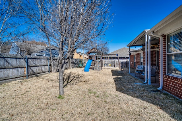 view of yard with a patio area, playground community, and a fenced backyard