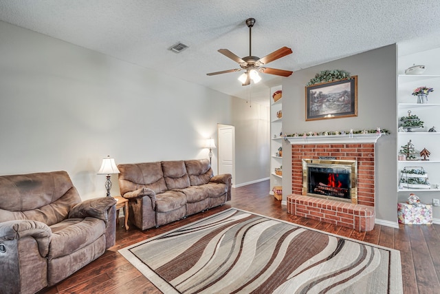 living room featuring a textured ceiling, built in shelves, hardwood / wood-style floors, and visible vents