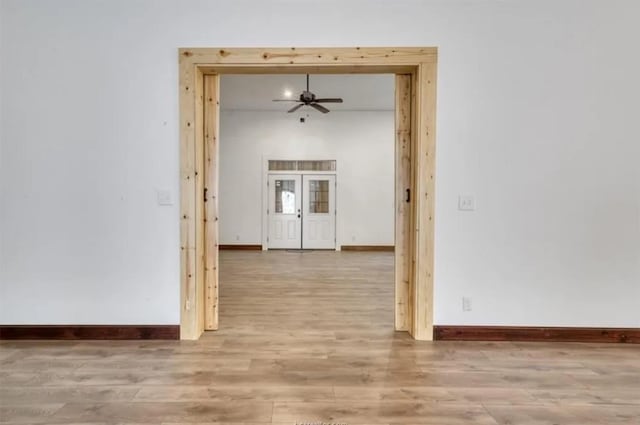 spare room featuring french doors, ceiling fan, baseboards, and wood finished floors