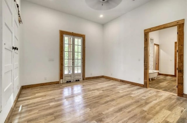 spare room with a ceiling fan, french doors, light wood-style flooring, and baseboards