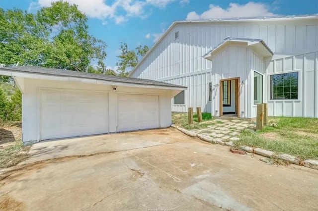 view of front of property featuring a garage, board and batten siding, and an outdoor structure