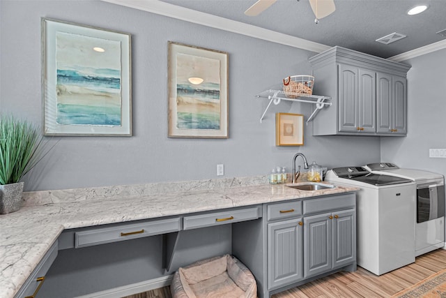 kitchen with crown molding, separate washer and dryer, a sink, and gray cabinetry