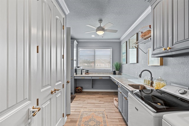 kitchen with ornamental molding, a sink, gray cabinetry, and separate washer and dryer