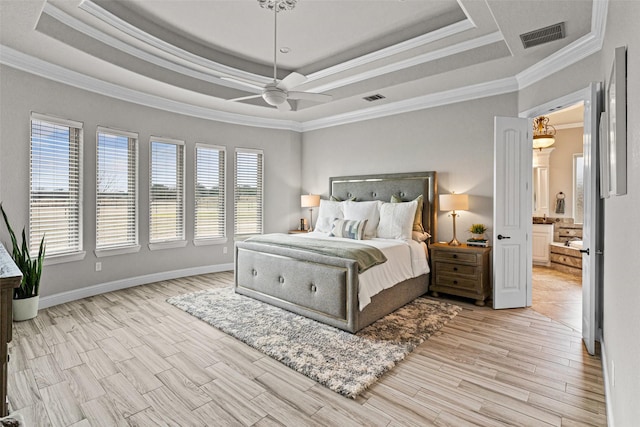 bedroom featuring a tray ceiling, light wood-type flooring, and visible vents