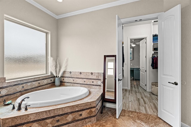 bathroom featuring a garden tub, a spacious closet, and ornamental molding