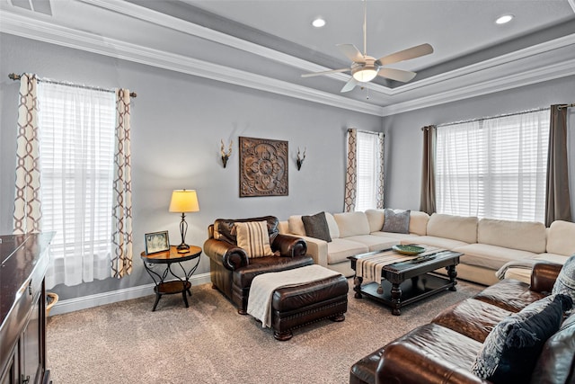 carpeted living area with baseboards, a raised ceiling, ceiling fan, ornamental molding, and recessed lighting