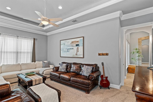 living area featuring visible vents, a raised ceiling, a ceiling fan, crown molding, and carpet floors