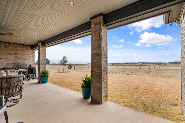 view of patio featuring a ceiling fan, a rural view, and a fenced backyard