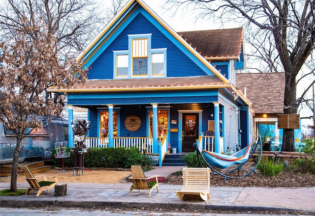 view of front of property featuring a shingled roof and a porch