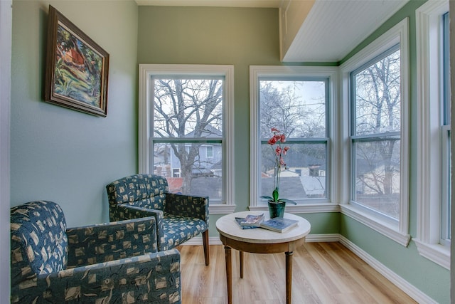 living area featuring light wood finished floors, plenty of natural light, and baseboards