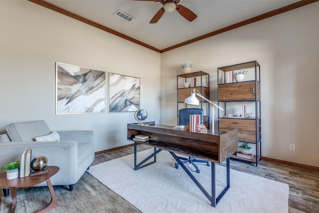 office area with ornamental molding, wood finished floors, visible vents, and baseboards