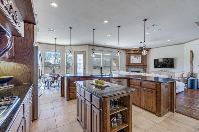 kitchen featuring a sink, visible vents, stainless steel appliances, and a large island with sink