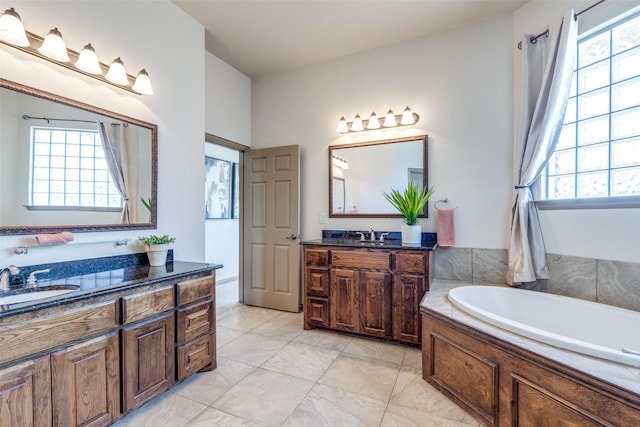 bathroom with two vanities, a sink, and a garden tub