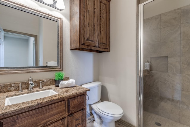 full bathroom featuring a stall shower, vanity, and toilet