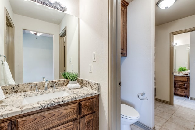 bathroom with toilet, tile patterned floors, and vanity