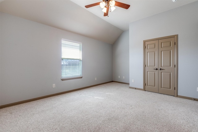 interior space featuring lofted ceiling, ceiling fan, and baseboards