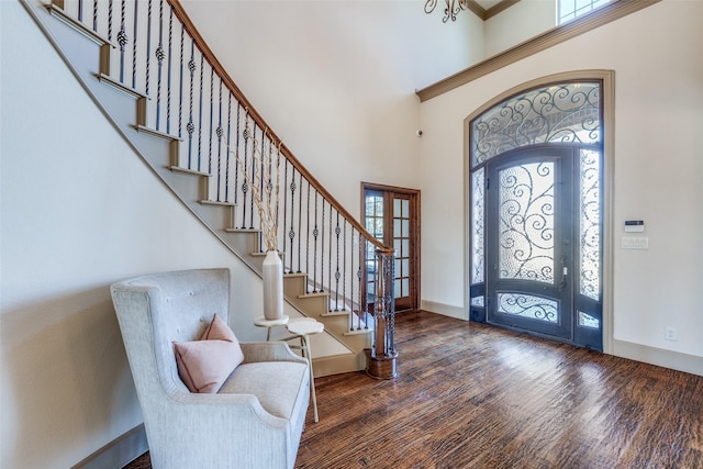 entrance foyer featuring baseboards, plenty of natural light, a high ceiling, and wood finished floors