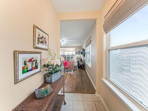 hall with baseboards and tile patterned floors