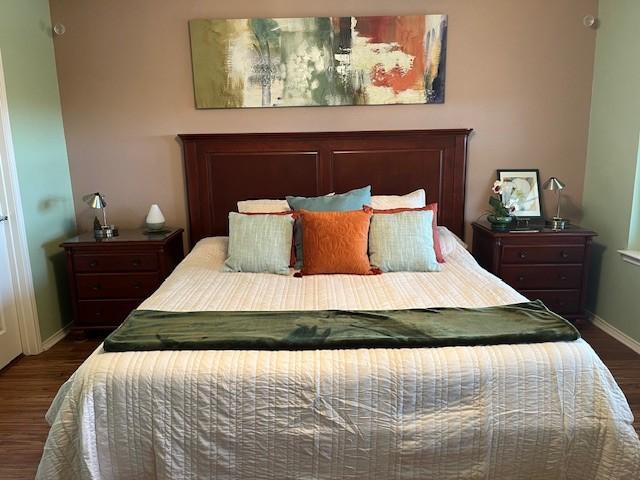 bedroom featuring dark wood-style flooring and baseboards