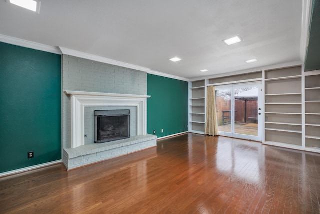 unfurnished living room with crown molding, a fireplace, and wood finished floors