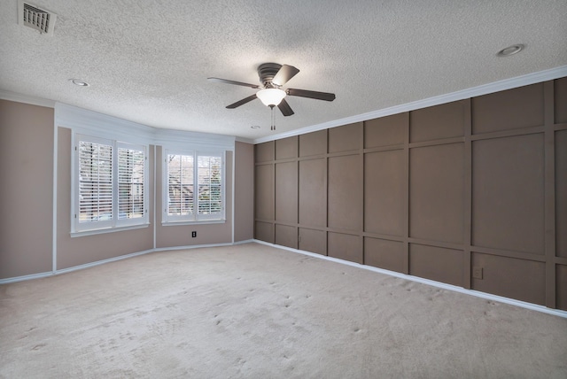 empty room featuring carpet, visible vents, and ornamental molding