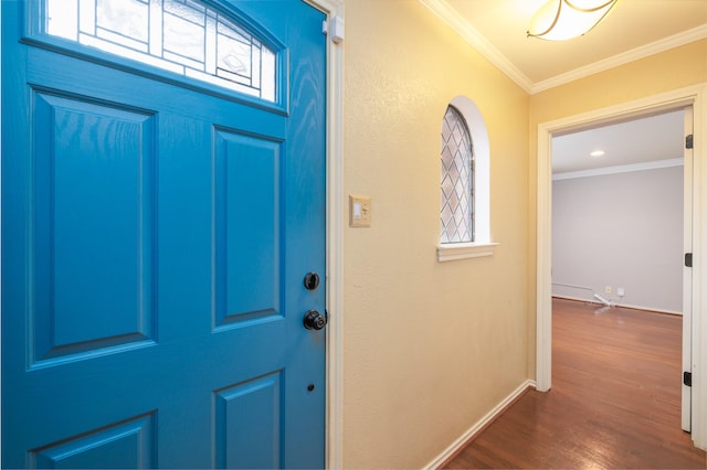 entryway with dark wood-style floors, ornamental molding, and baseboards