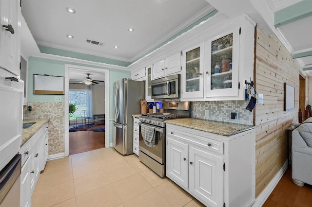 kitchen featuring light tile patterned floors, visible vents, stainless steel appliances, crown molding, and white cabinetry