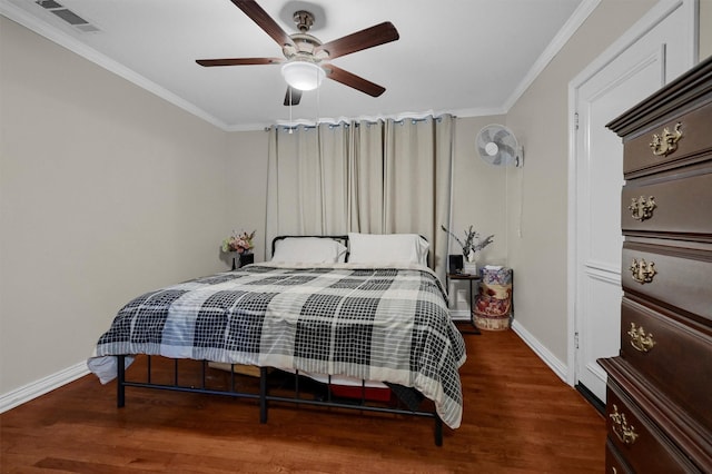 bedroom featuring baseboards, visible vents, crown molding, and wood finished floors