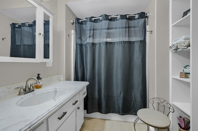 bathroom with tile patterned flooring, a shower with curtain, a textured ceiling, and vanity