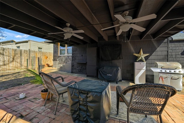 view of patio with fence, area for grilling, and ceiling fan