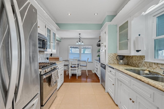 kitchen featuring light tile patterned floors, stainless steel appliances, backsplash, glass insert cabinets, and white cabinets