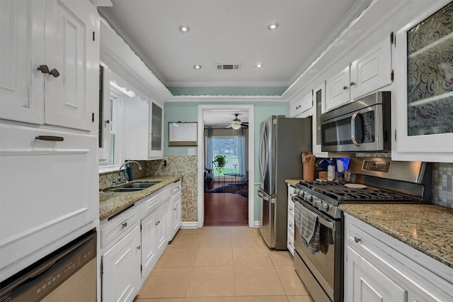 kitchen featuring light tile patterned floors, white cabinetry, stainless steel appliances, and a sink