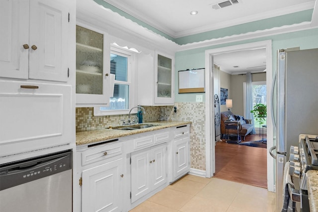 kitchen featuring visible vents, appliances with stainless steel finishes, ornamental molding, light tile patterned flooring, and a sink