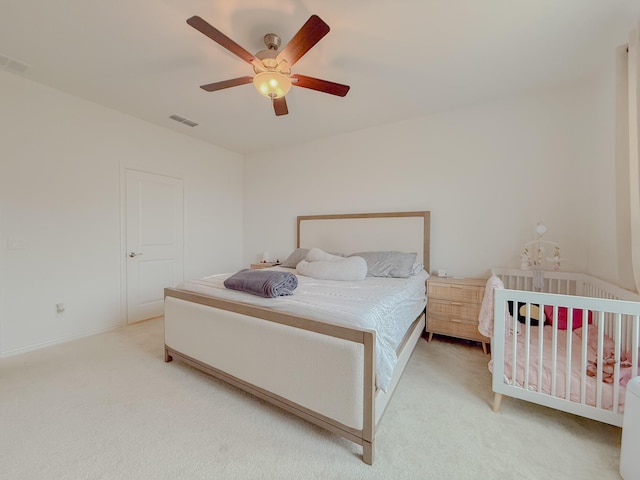 carpeted bedroom with ceiling fan and visible vents