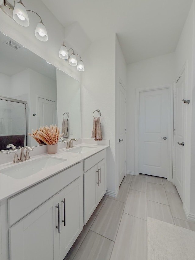 full bath with a stall shower, visible vents, a sink, and double vanity