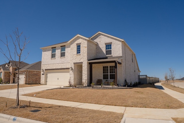 traditional-style home with driveway, stone siding, an attached garage, covered porch, and brick siding