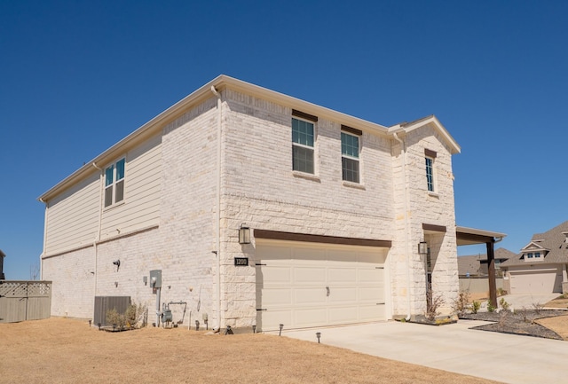 view of side of property featuring a garage, central AC, brick siding, and concrete driveway