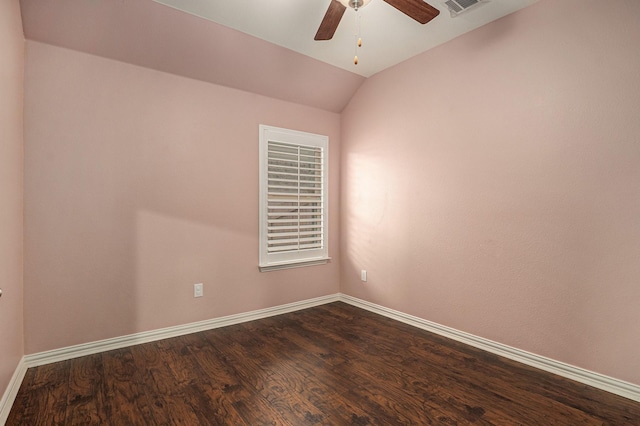 spare room featuring visible vents, baseboards, dark wood finished floors, vaulted ceiling, and a ceiling fan