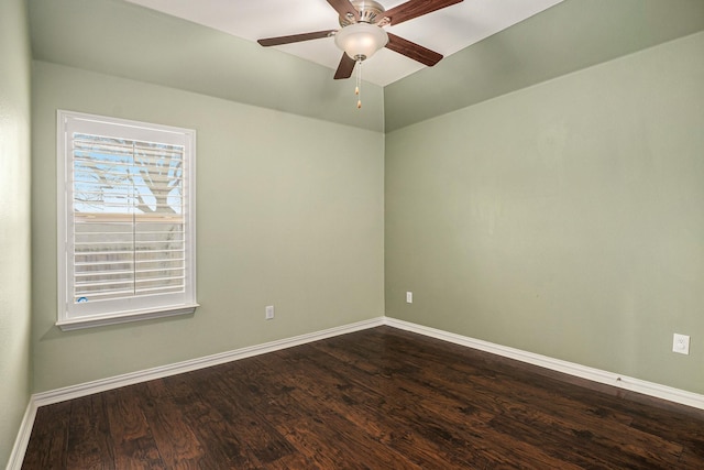 empty room featuring baseboards, lofted ceiling, dark wood finished floors, and a ceiling fan