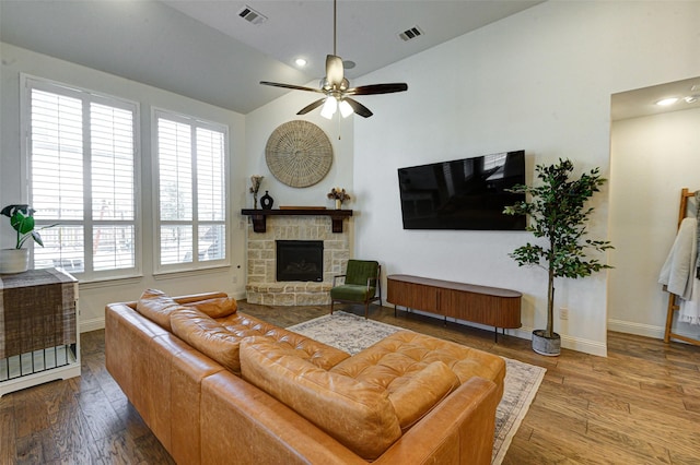 living area with vaulted ceiling, wood finished floors, and visible vents