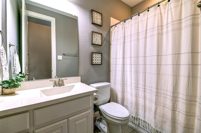 full bathroom featuring toilet, a textured wall, a shower with curtain, and vanity