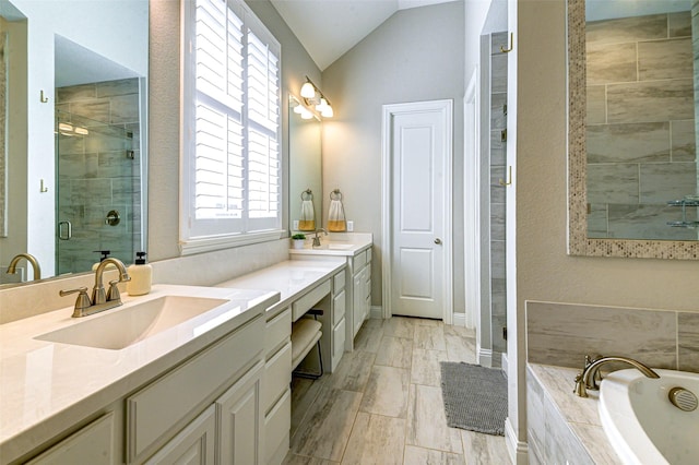 bathroom with lofted ceiling, a sink, a bath, double vanity, and a stall shower